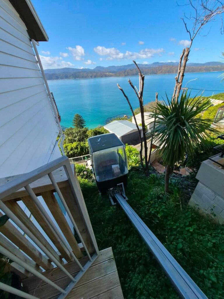 Moving boxes going up a hillside cable car above Wellington Harbour