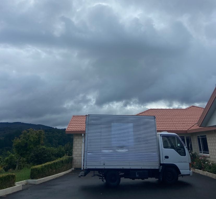 Moving truck in the driveway of a hillside home