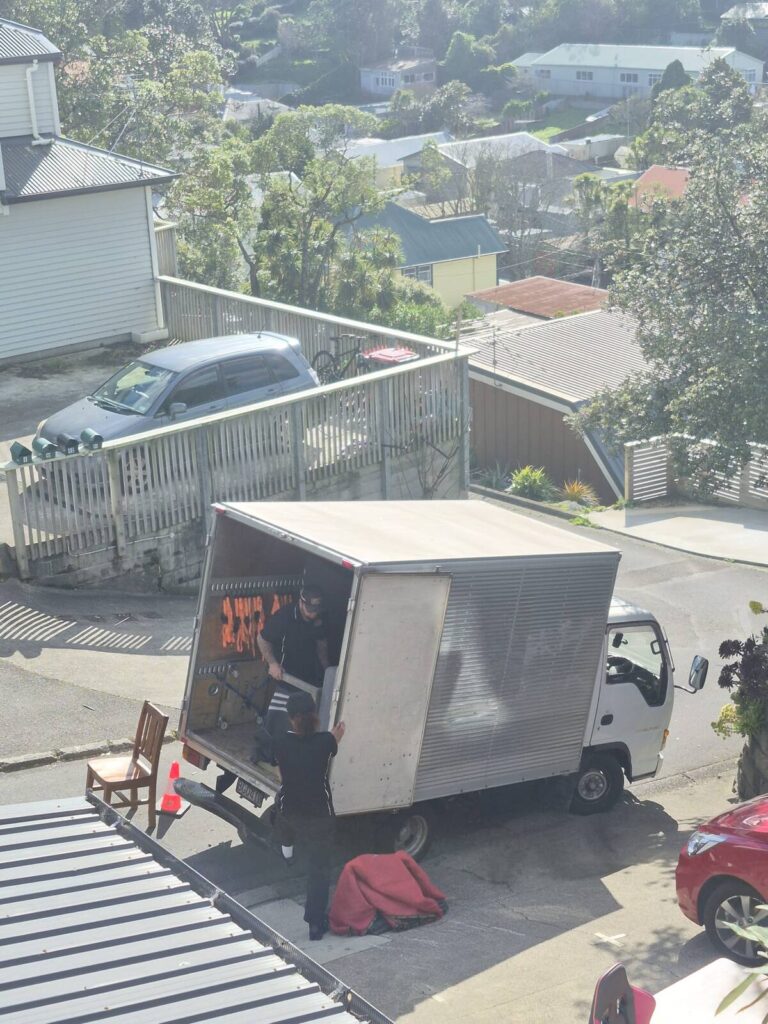 Movers loading furniture into the Central Relocations truck